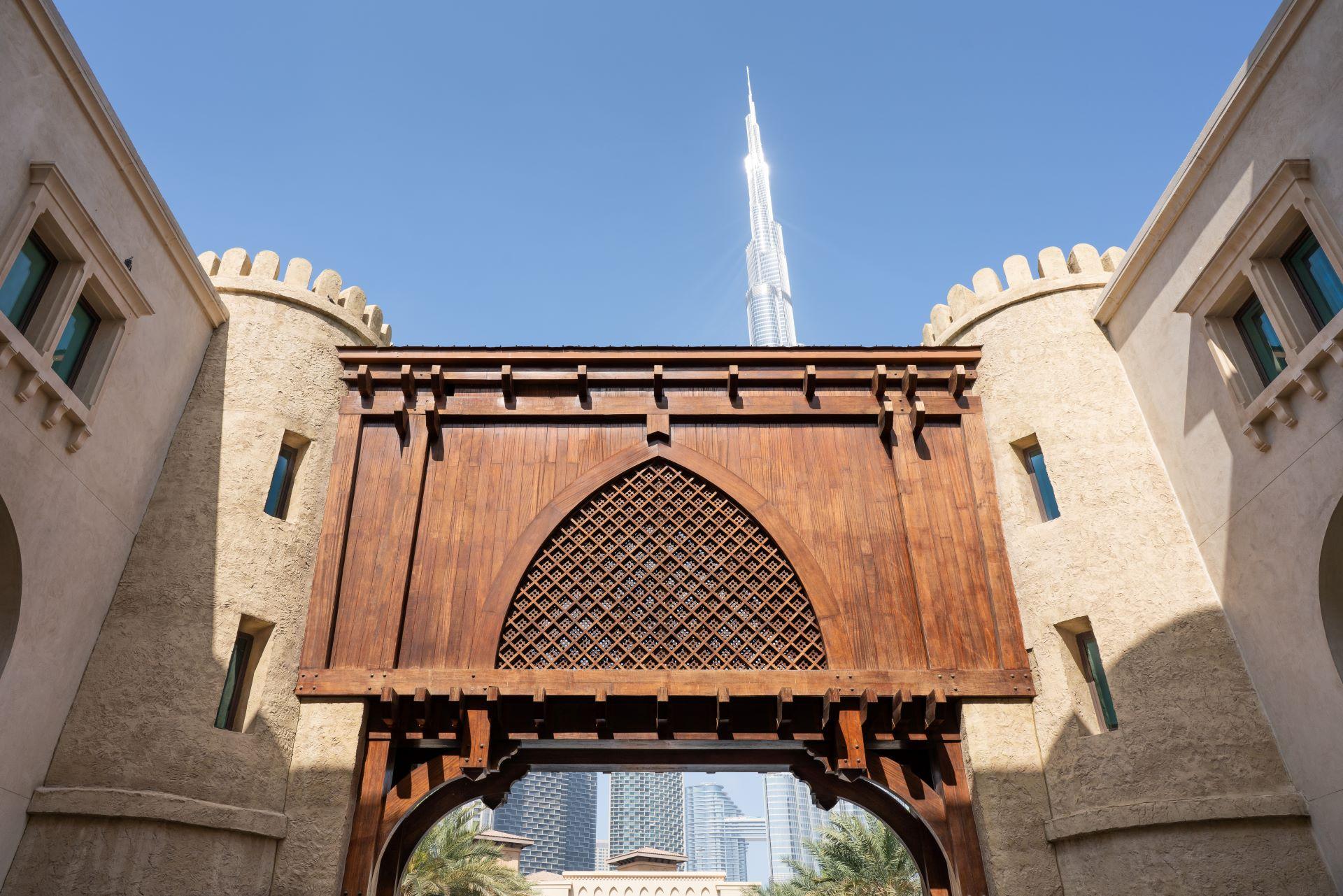 Burj Khalifa hinter traditioneller Architektur in Dubai.