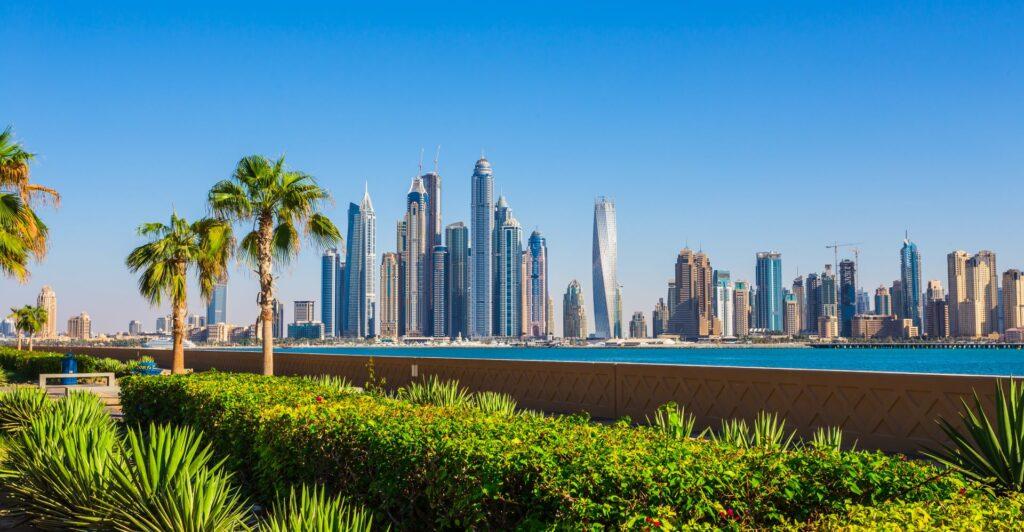 Dubai Skyline mit Grünanlagen und Palmen.