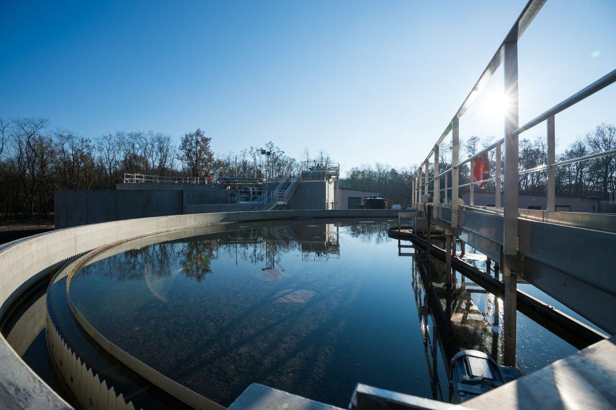 Moderne Wasseraufbereitungsanlage mit klarem Wasser und Sonnenschein – essenziell für die Befüllung von Trinkwasserbehältern.