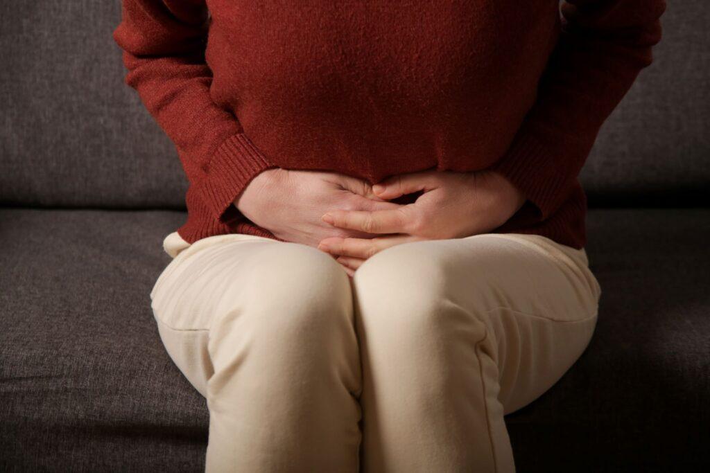 Frau mit Bauchschmerzen auf dem Sofa