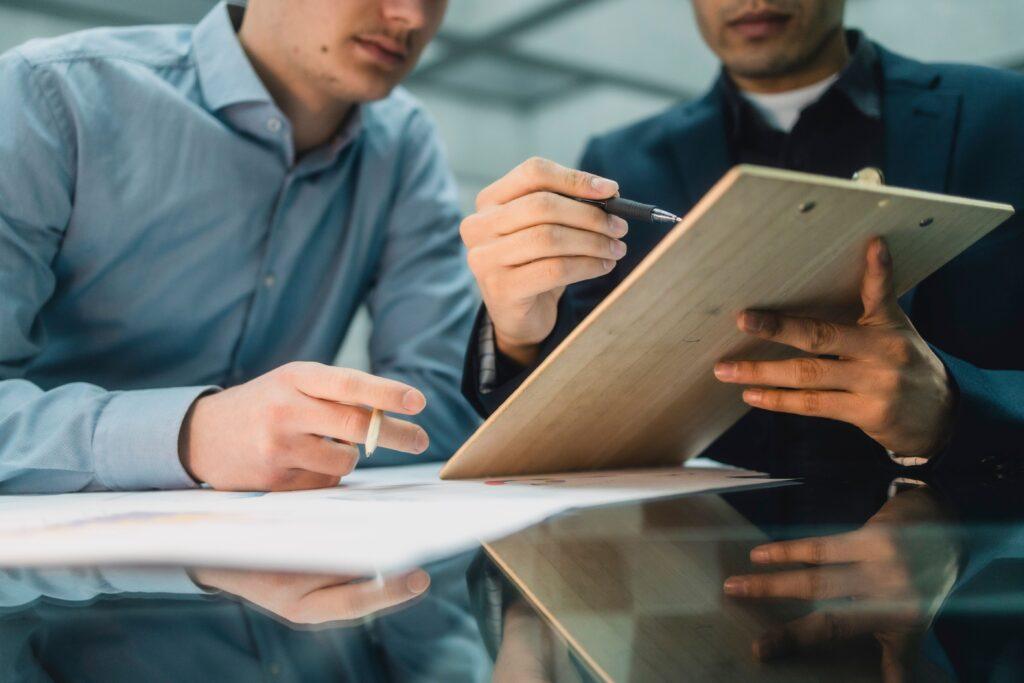 Beratungssituation zweier Personen, die Unterlagen prüfen und Entscheidungen zum Schreckschusswaffen kaufen vorbereiten